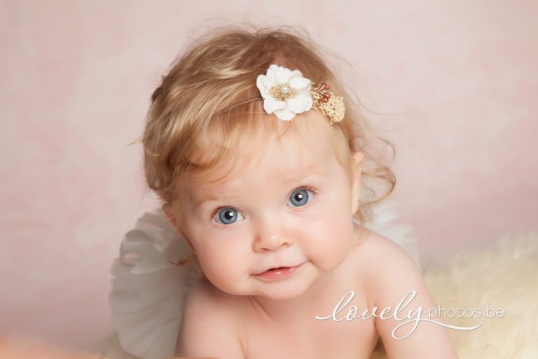 Baby met blauwe ogen en bloemenhaarband – babyportret in de fotostudio in Hasselt