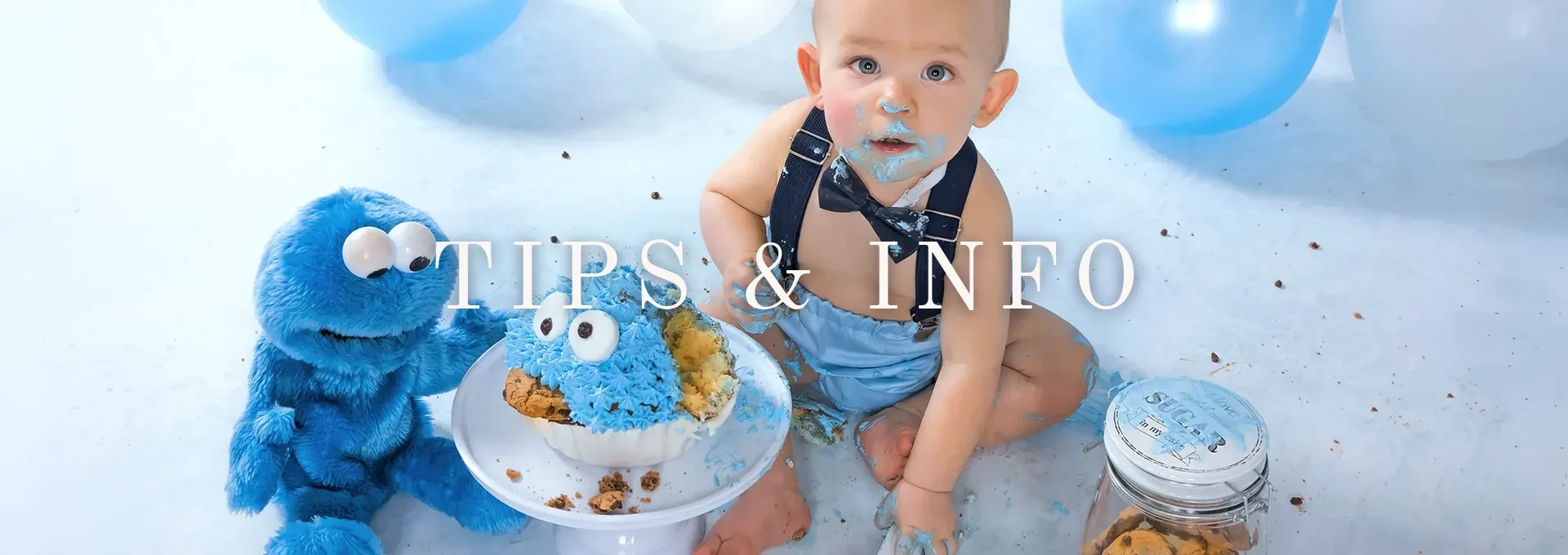Jongen van één jaar met blauwe taart tijdens een cakesmash fotoshoot in Hasselt, met de tekst Tips & Info