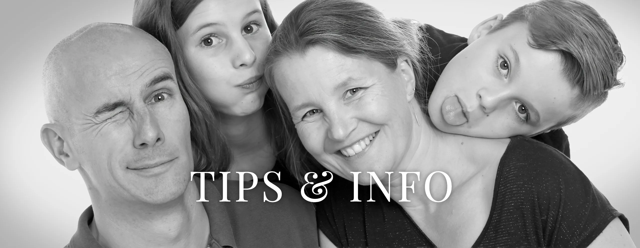 Speelse zwart-witfoto van een gezin met vader, moeder, dochter en zoon die grappige gezichten trekken – family fotoshoot bij Lovely-Photos in Hasselt, met de tekst Tips & Info