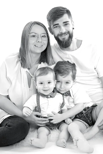 Zwart-witfoto van een gezin met twee jonge zoontjes die samen op de grond zitten – family fotoshoot in de fotostudio van Lovely-Photos in Hasselt